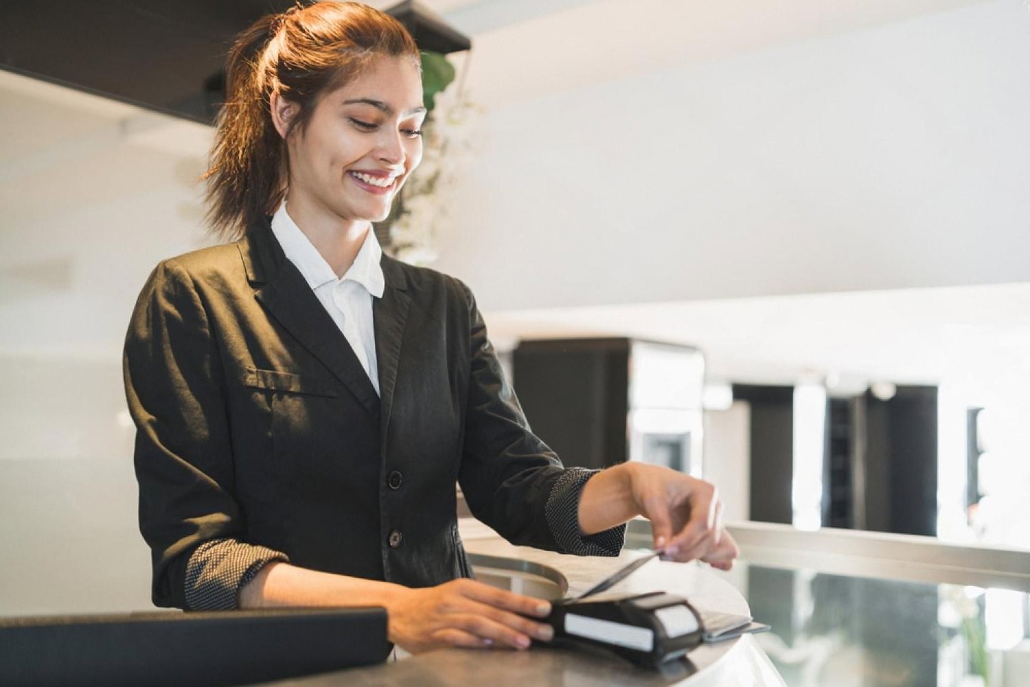 Hotel staff member processing a digital key on a contactless reader