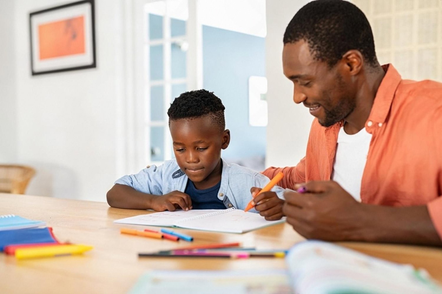 Father helping son with a colourful drawing and writing task at home