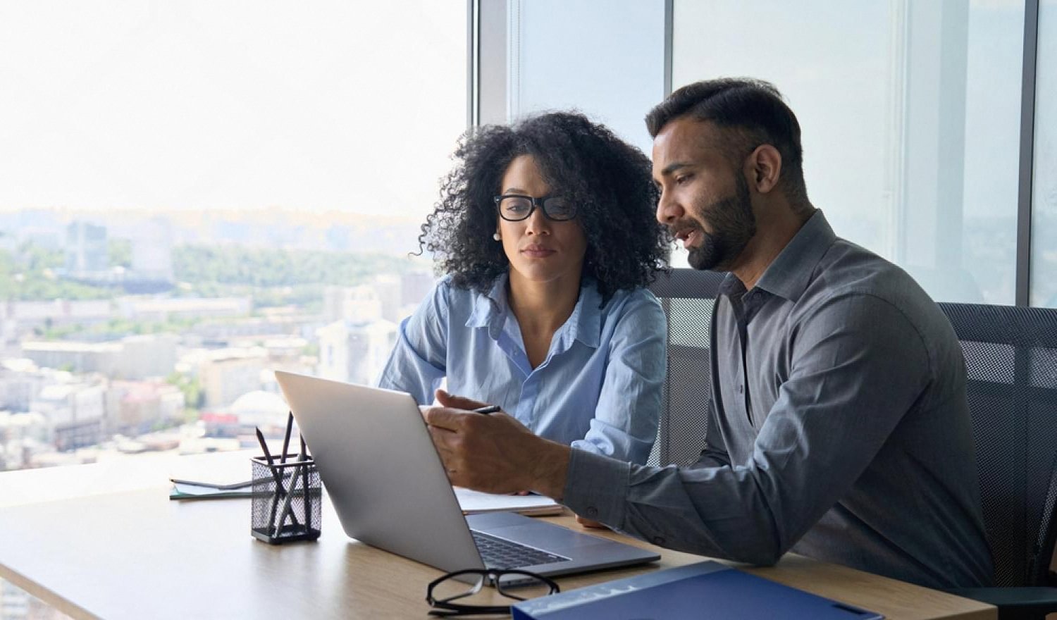 Insurance broker and client reviewing policy options on a laptop in a UAE office